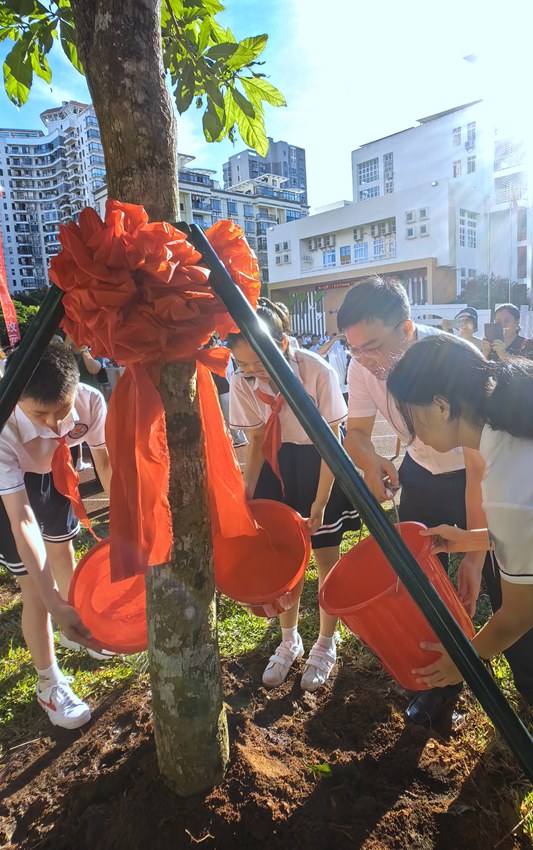 師生共同植樹。?？谑械?5小學(xué)供圖