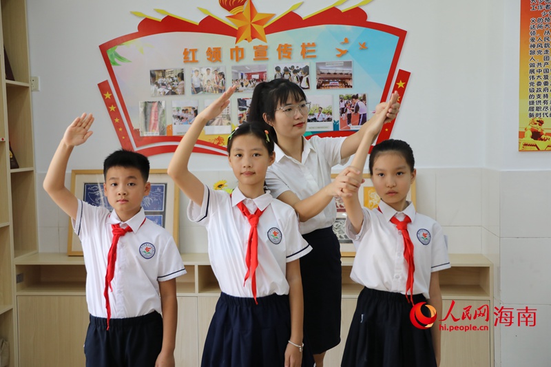 黃雨媚老師糾正同學行中國少年先鋒隊隊禮的姿勢。 人民網記者 孟凡盛攝