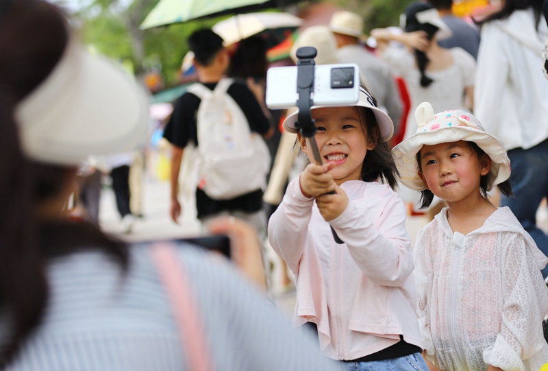 5月3日，家長(zhǎng)帶著孩子在三亞南山文化旅游區(qū)游覽。