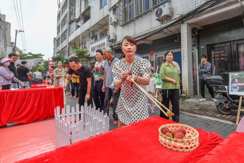 現(xiàn)場設(shè)置的“長筷夾荔枝”挑戰(zhàn)，緊張有趣。  主辦方供圖