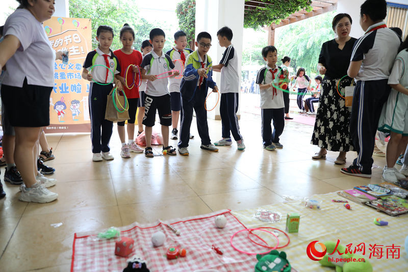 5月31日，在海口市第二十五小學公益跳蚤市場上，學生通過做游戲來贏得喜愛的物品。 人民網(wǎng)記者 孟凡盛攝