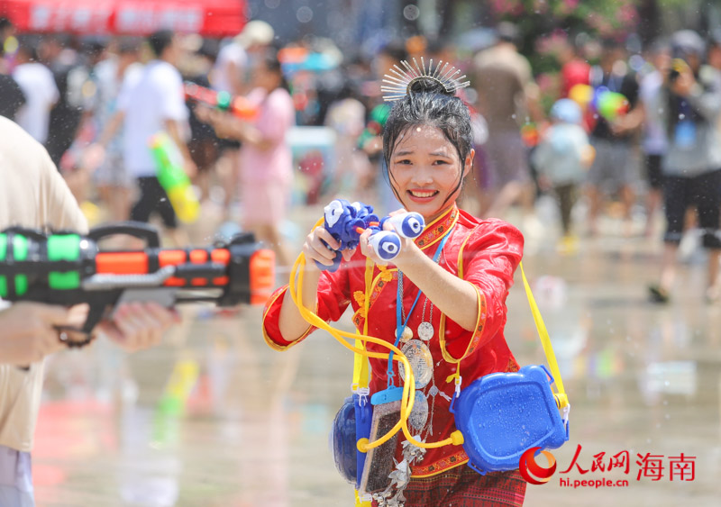 一名穿著少數(shù)民族服飾的女子，拿起裝備參與這場狂歡。人民網(wǎng)記者 牛良玉攝